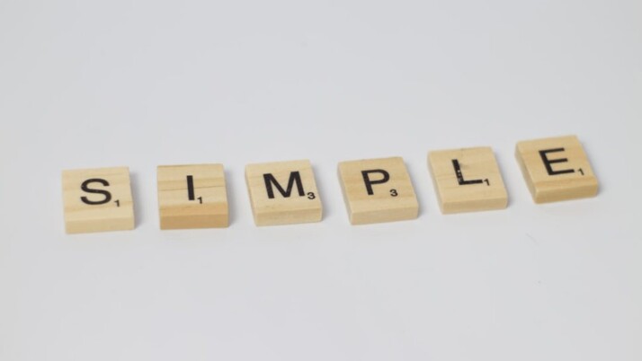 Wooden scrabble blocks with the word SIMPLE placed against a white background