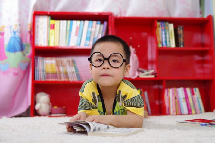 A young boy in kindergarten class preparing to read a book