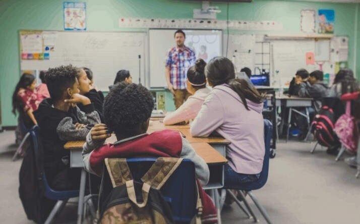 Teacher and students in class preparing to do assessments and learn