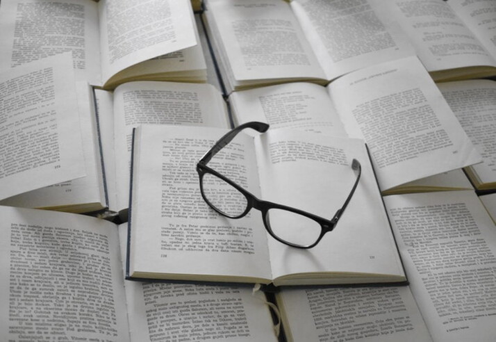 A black framed eyeglass placed on white book page