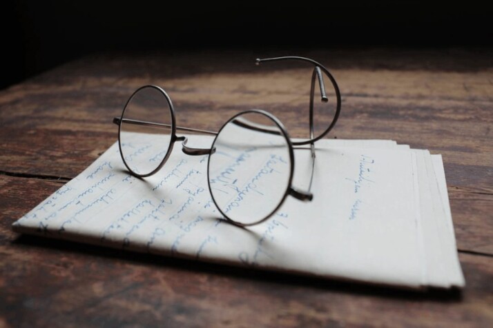 A silver framed eyeglasses placed on a white printer paper