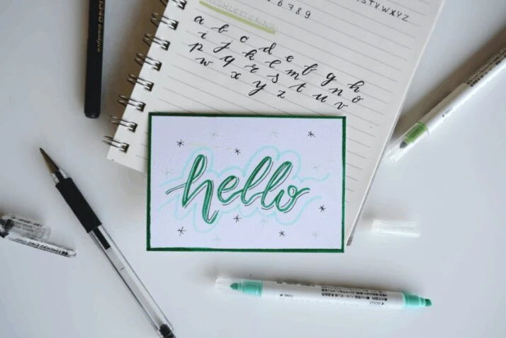 A green and white Hello board decor on a white surface