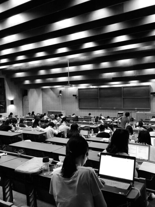 a black and white photo of students in the lecture hall.