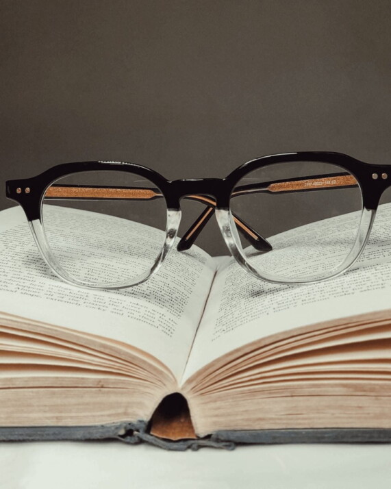 black framed eyeglasses on book page above a table