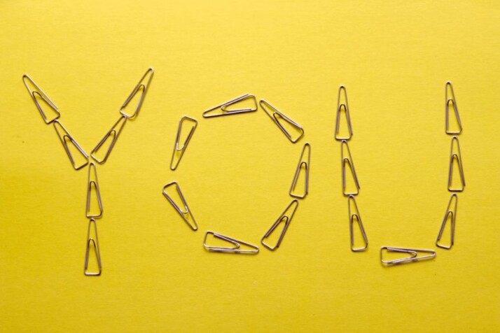 silver framed eyeglasses on yellow surface showing the word 