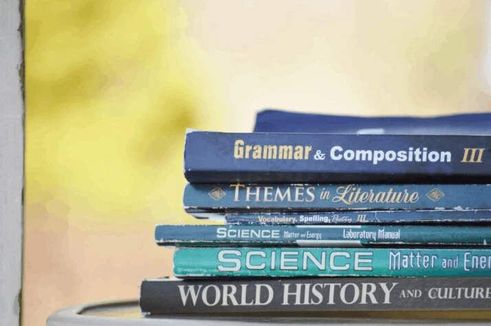 A pile of blue colored assorted-title books kept on a table