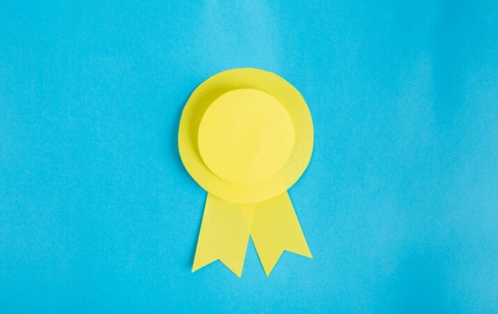 A bright yellow ribbon pictured against a blue background.