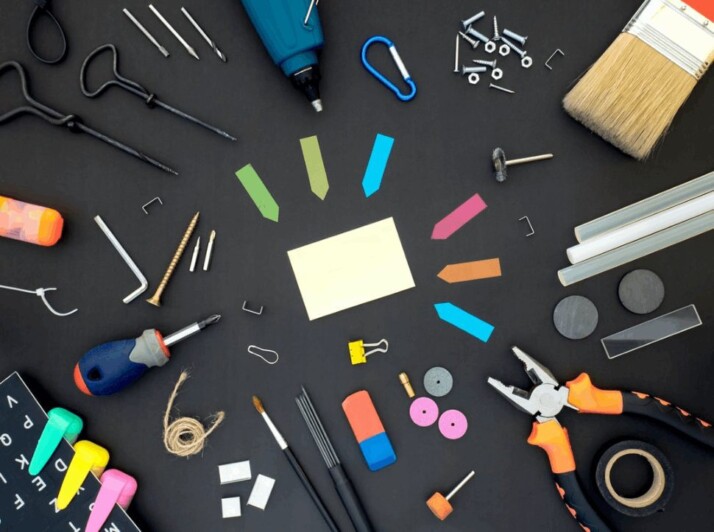 assorted color plastic tools on a gray wooden table