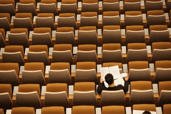 a student in a lecture hall studying by himself.