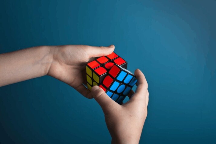 A person trying to playing with a rubix cube to solve it.