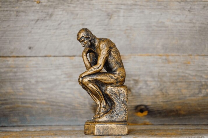 a smaller replica of the famous thinker statue by Auguste Rodin.