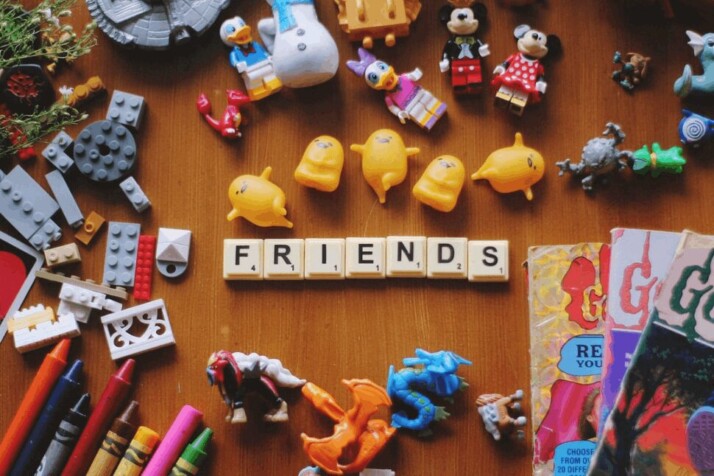 assorted-color toy lot with FRIENDS scrabble blocks on a wooden surface