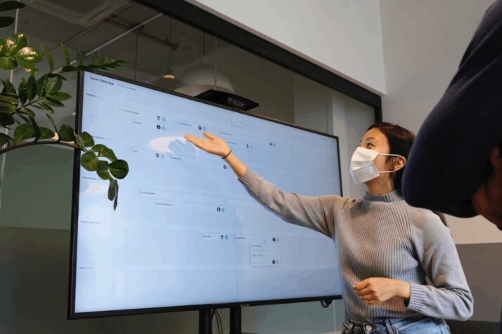 A woman in white, delivering a presentation to someone.