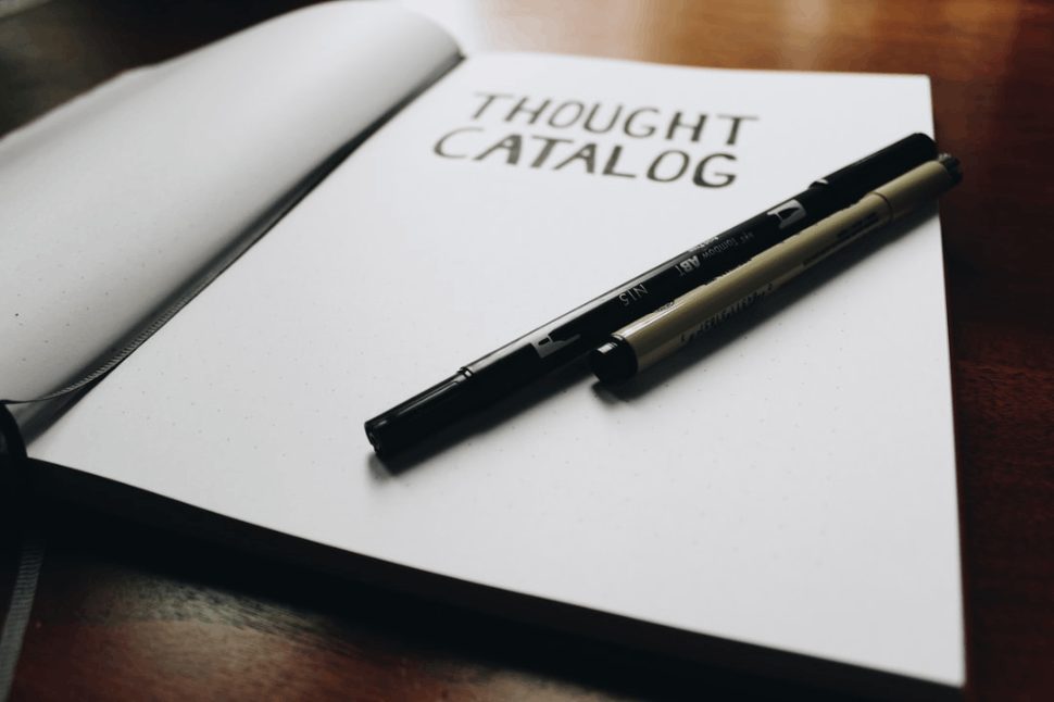 close-up photo of opened Thought Catalog book with pen on it
