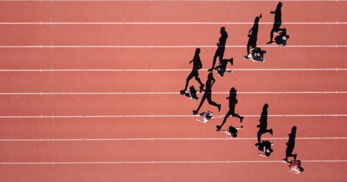 runners running with the v formation on an olympic track.