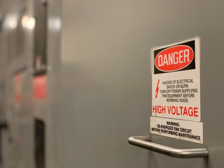 Danger High Voltage Sign Post on Electrical Switchgear Equipment.
