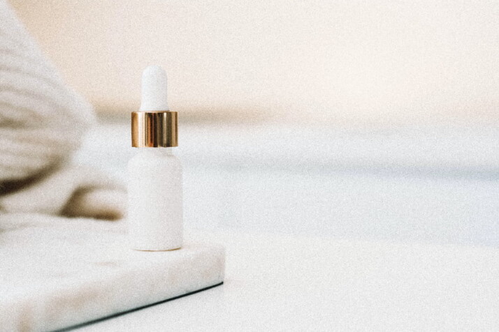 A white and gold skin care bottle with no label.