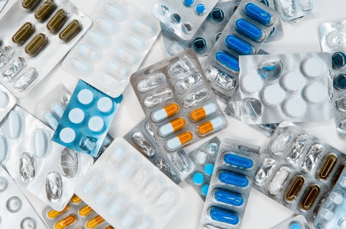 A variety of pharmaceutical drugs laid out on a blank white table.