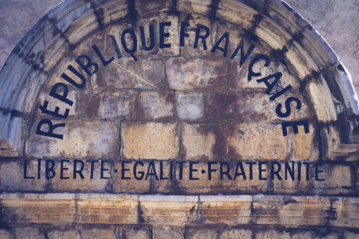a stone arch that says French republic, followed by the republican motto.
