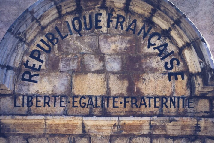 a stone arch that says French republic, followed by the republican motto.