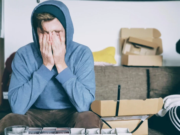 A man looking stressed with his hands pressed against his face.