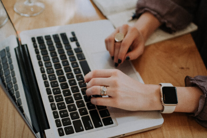 A person working on a laptop using both hands.