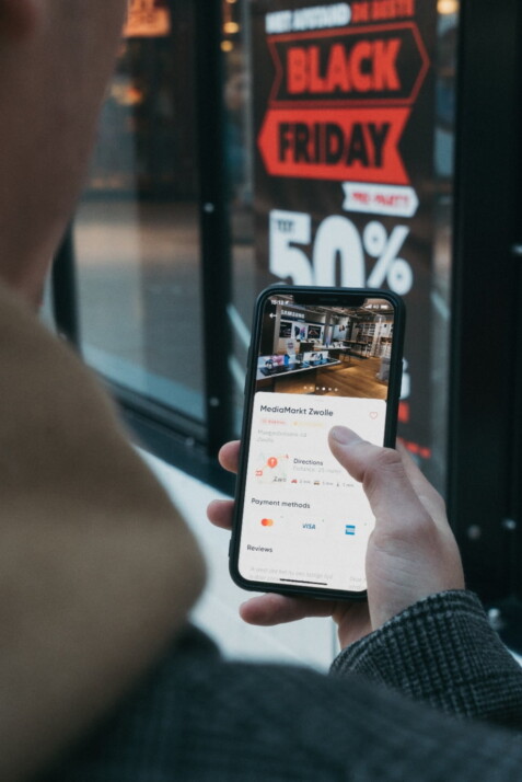 person buying something from an online store in front of a physical store.