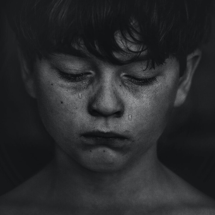 Black and white picture of a young boy with tears rolling down his face