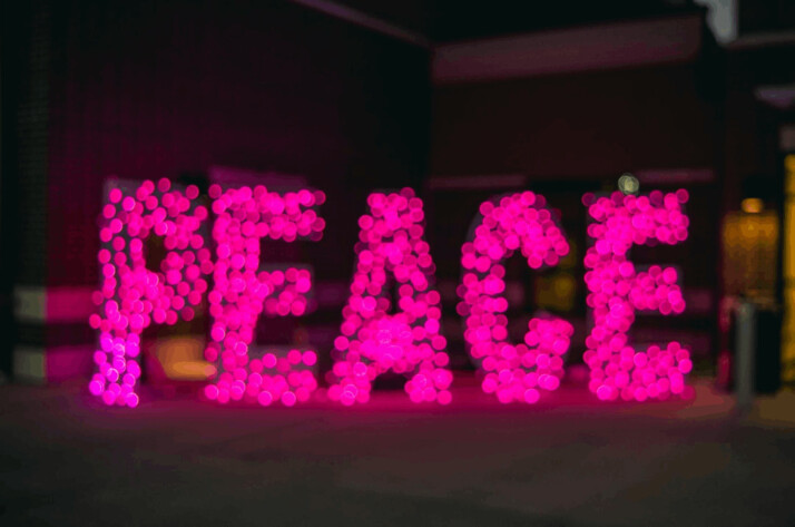 Peace neon signage on room floor lighting up the room