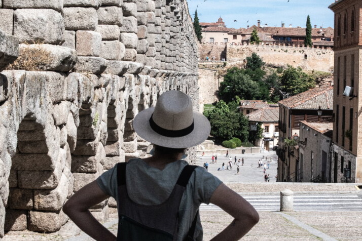 A tourist stands with their back to the camera