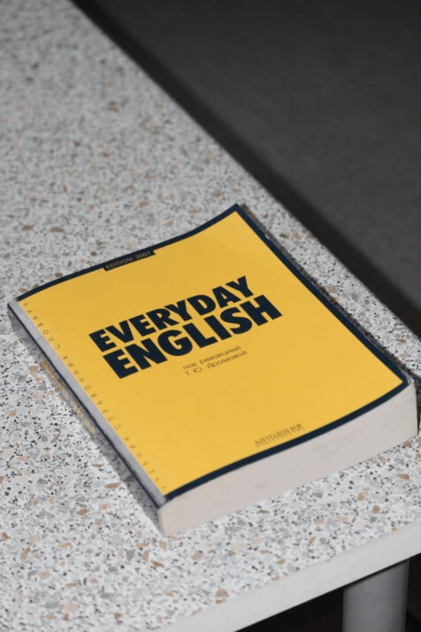 A book with a yellow cover titled Everyday English on a white table