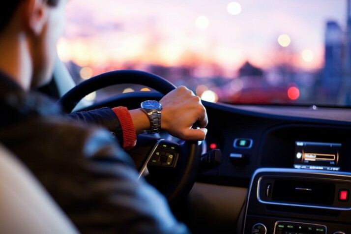 A man driving a car with nice interiors.