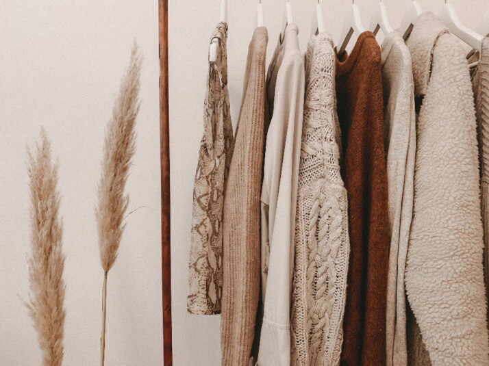 A nice rack of clothes that have neutral colors.
