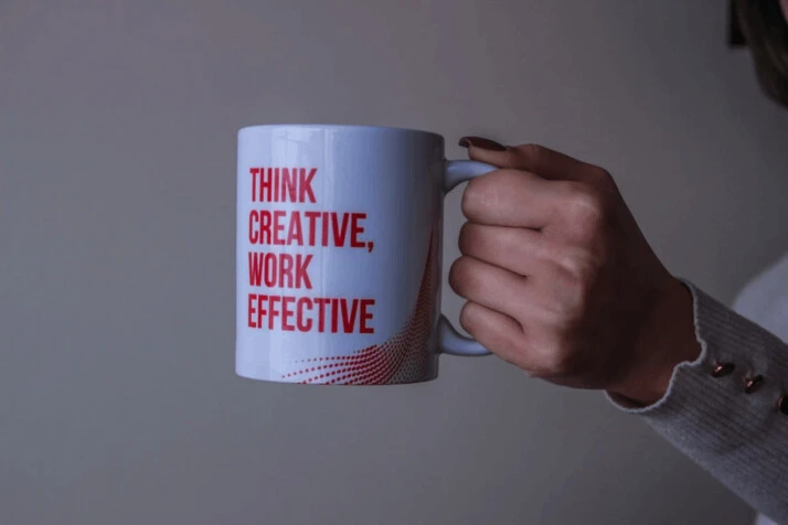 white and red ceramic mug with text 