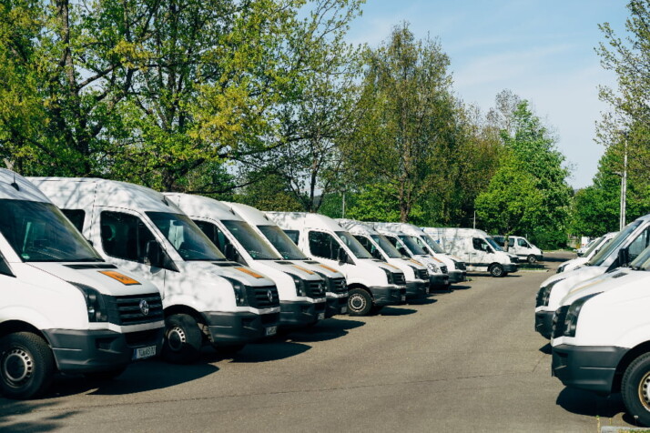 A line of white vans parked along the street.