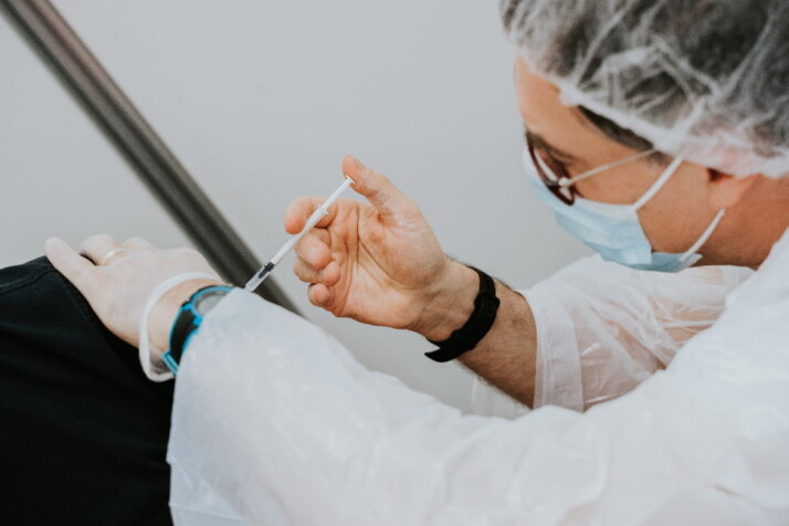 Health practitioner injecting a patient.