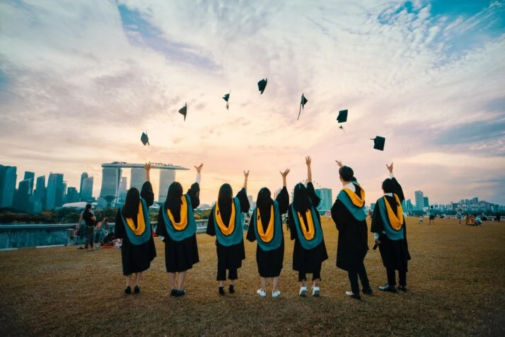 A group of graduates throwing their grad caps in the air.