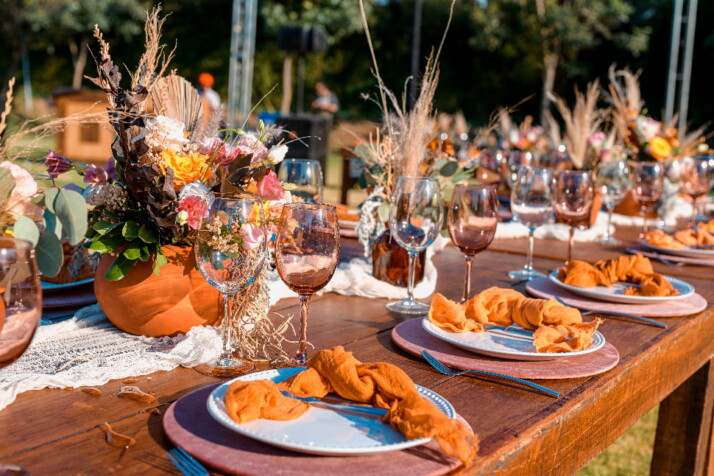 Table for group eating adorned with food plate and glasses of wine