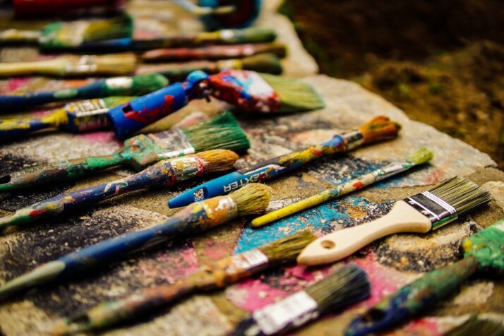 Numerous used painting brushes after a hard day of work waiting to be cleaned.