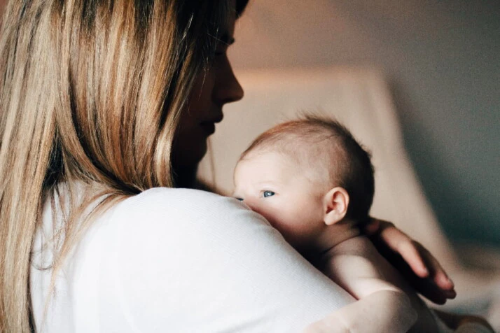 A mother holding her new baby in her arms.