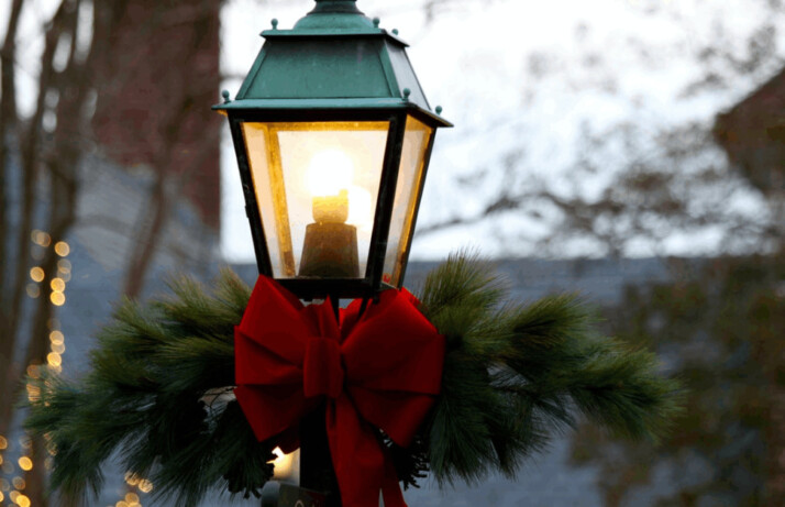 A red and black metal lantern lighted for Christmas