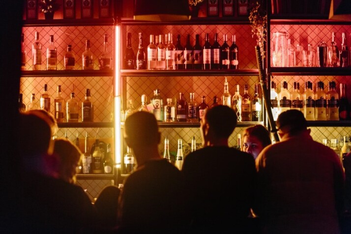 A picture of a group of people sitting inside a bar.