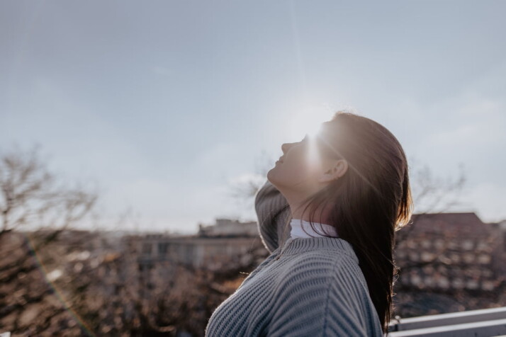 An image of a beautiful girl facing the sky on a sunny day