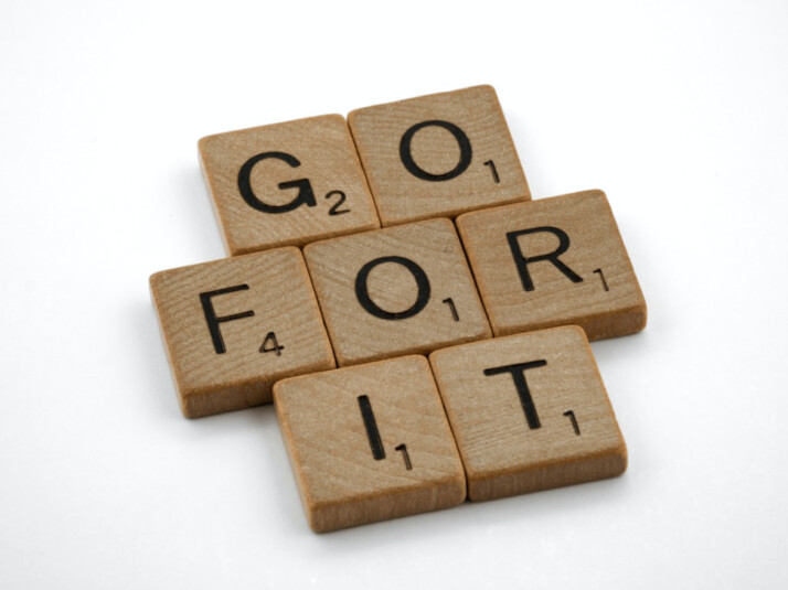 GO FOR IT brown wooden scrabble blocks on a white background