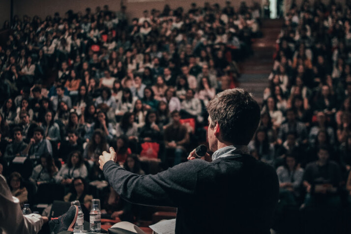 A person giving a speech in front of a huge audience