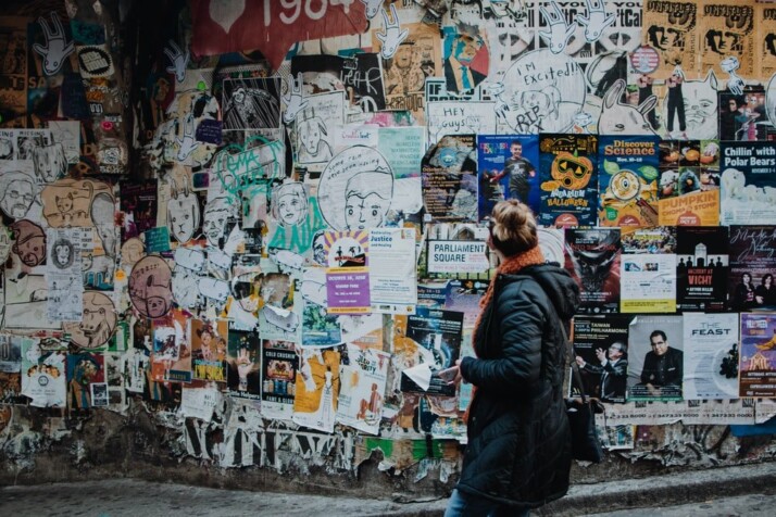 person standing beside wall during daytime