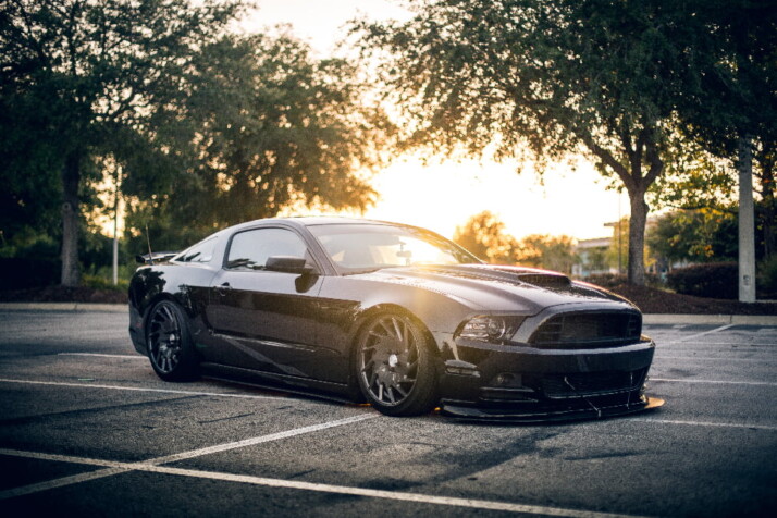 A cool all black car running on the road.