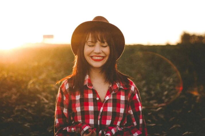 A girl wearing a red outfit and red lipstick and smiling