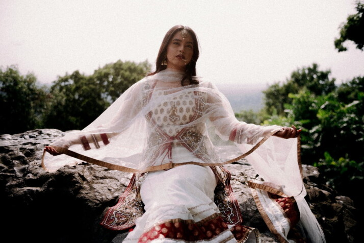 A woman wearing a beautiful piece of clothing known as a Lehenga.