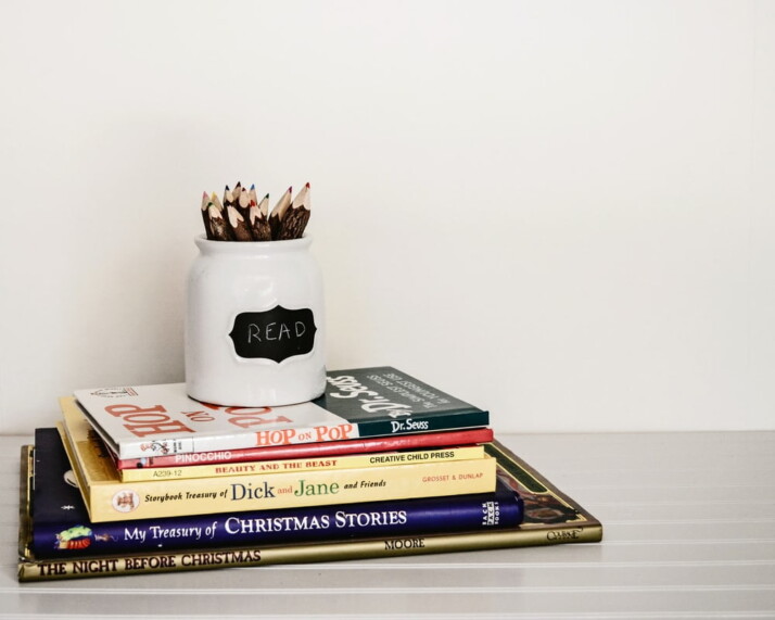 white ceramic pencil organizer on top of stack of books